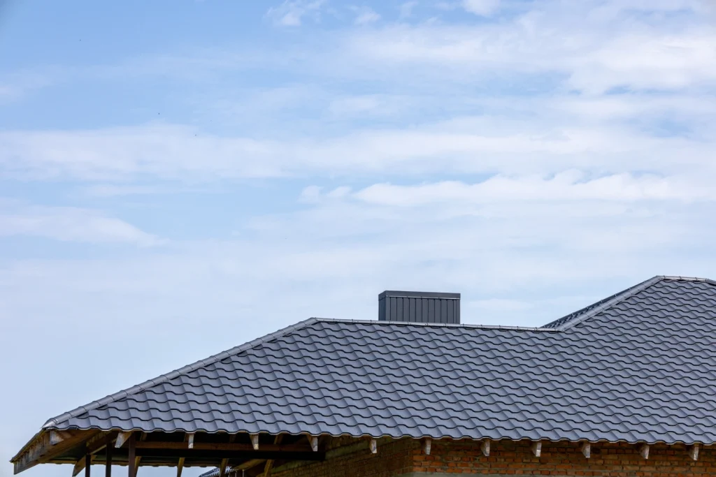the roof of a new house features gray tiles under a vast blue sky with soft clouds showcasing a serene rural atmosphere free photo 1